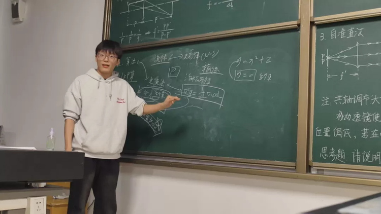 团队成员在黑板前讲解光路原理和计算方法